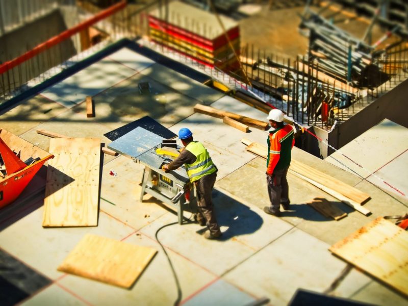 A birds eye image of two construction workers working on site.