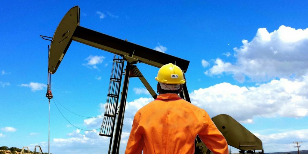 Photo of an individual looking at an oil rig.