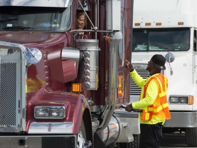 Worker talking to a truck driver.