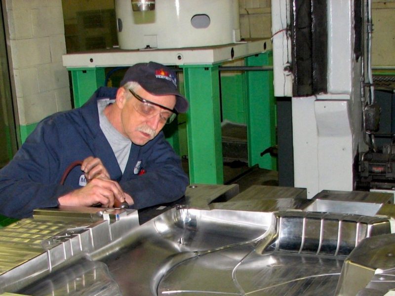 A technician working on an injection mold