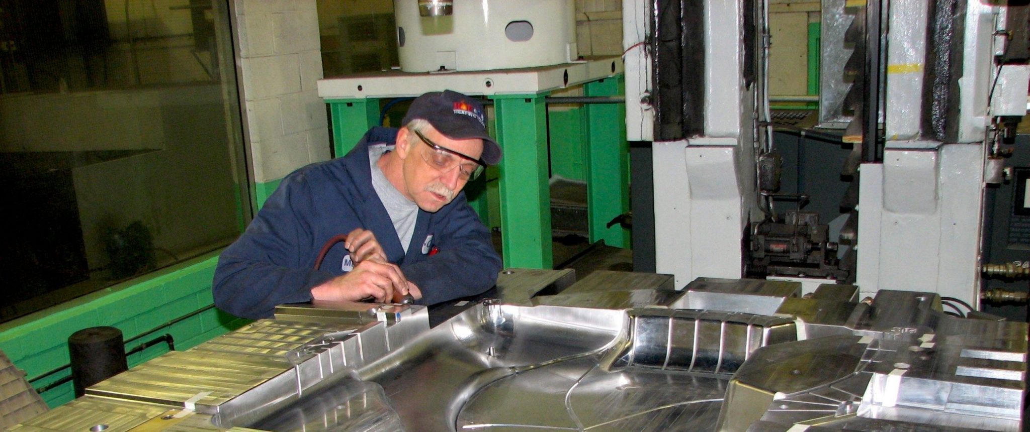 A technician working on an injection mold