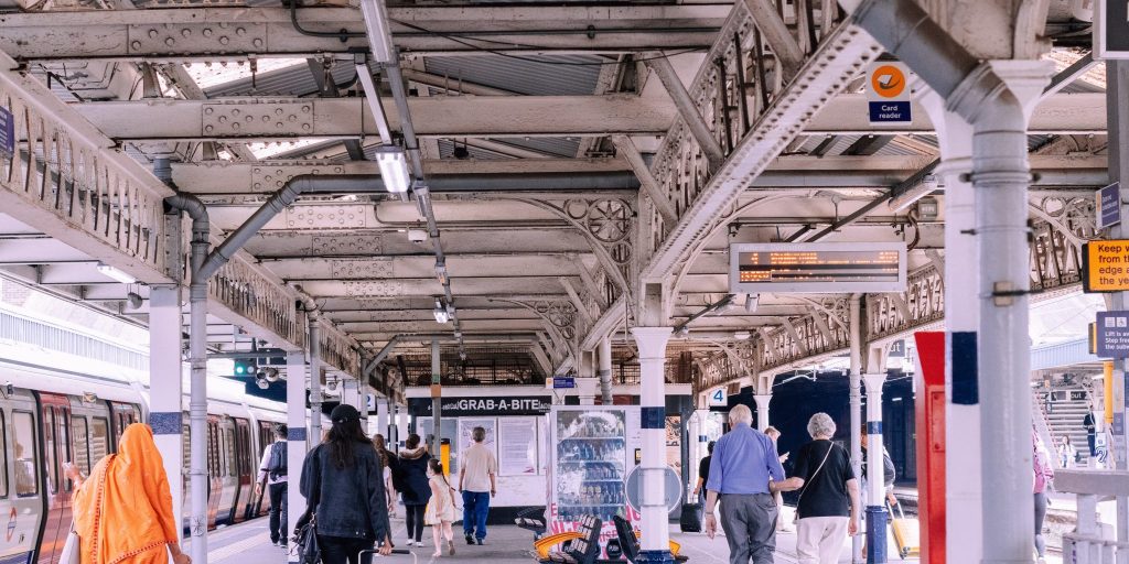 Individuals walking on a busy subway or train platform.