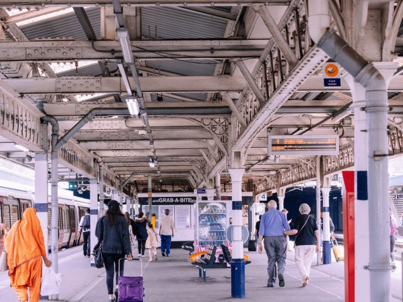 Individuals walking on a busy subway or train platform.