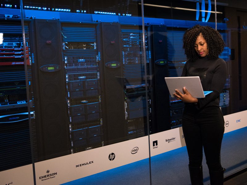 Professional women working with her laptop next to machinery.