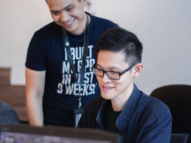 Person at computer with someone standing behind them looking at the screen