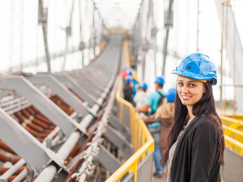 Person wearing blue hard hat and smiling