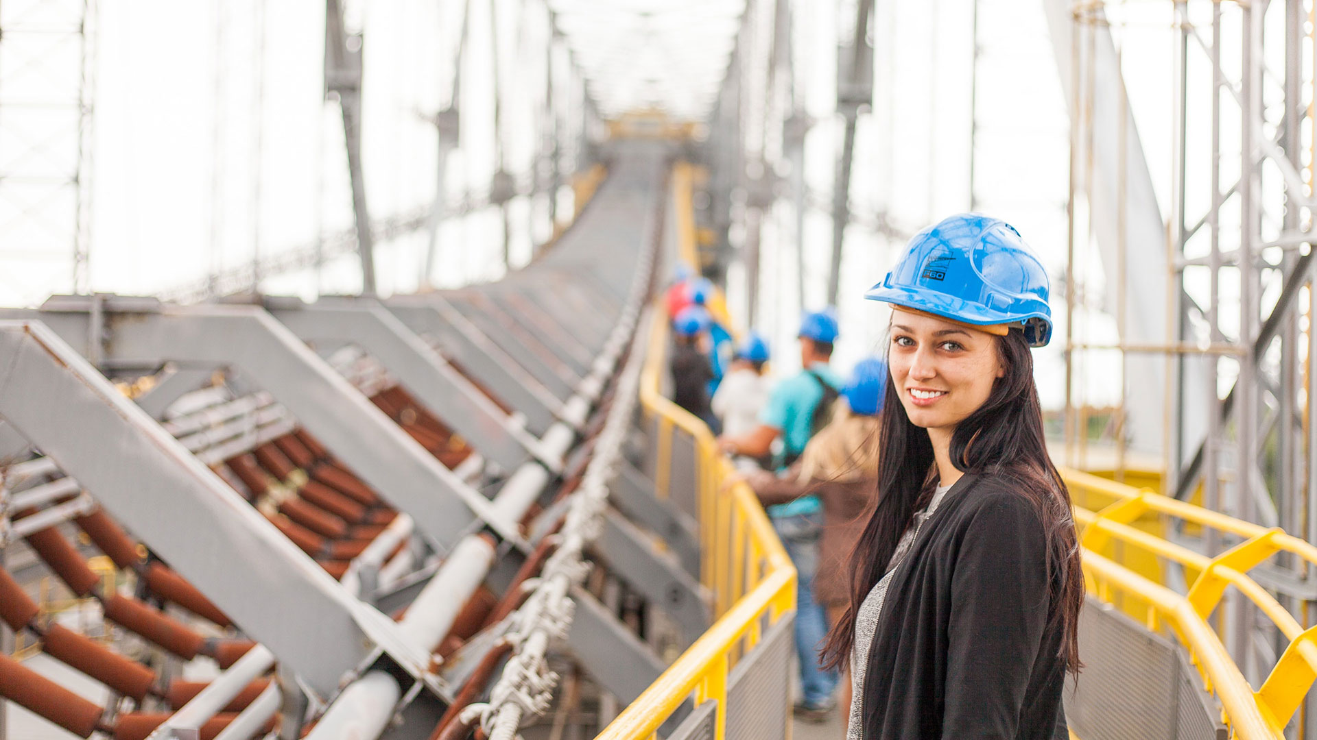 Person wearing blue hard hat and smiling