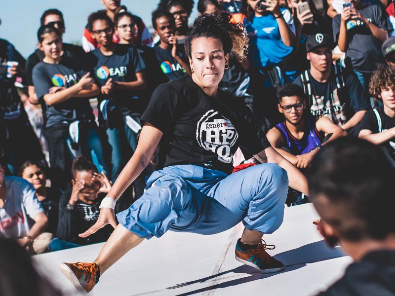 Breakdancer on the dance floor surrounded by a diverse audience