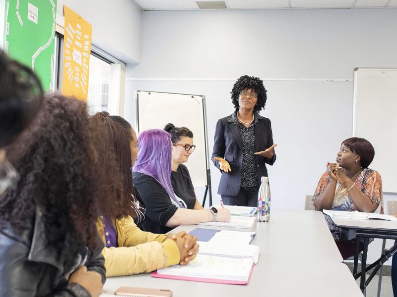 Person giving whiteboard presentation to a diverse group