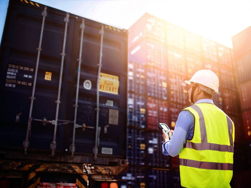 Shipyard worker holding an electronic device