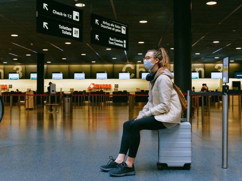 woman sitting on luggage at the Swiss airport