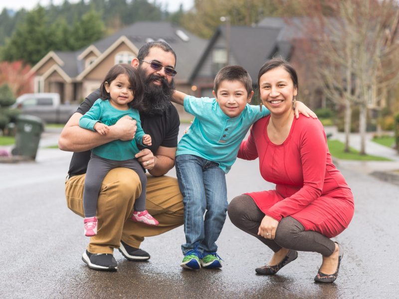 Father, mother and two young children hugging