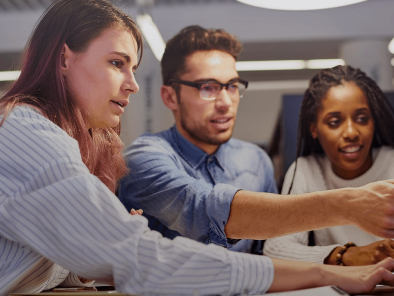 Group of students collaborating over a computer sreen