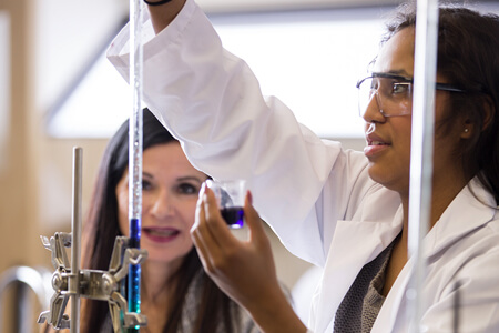 Two women in a lab with test tubes.