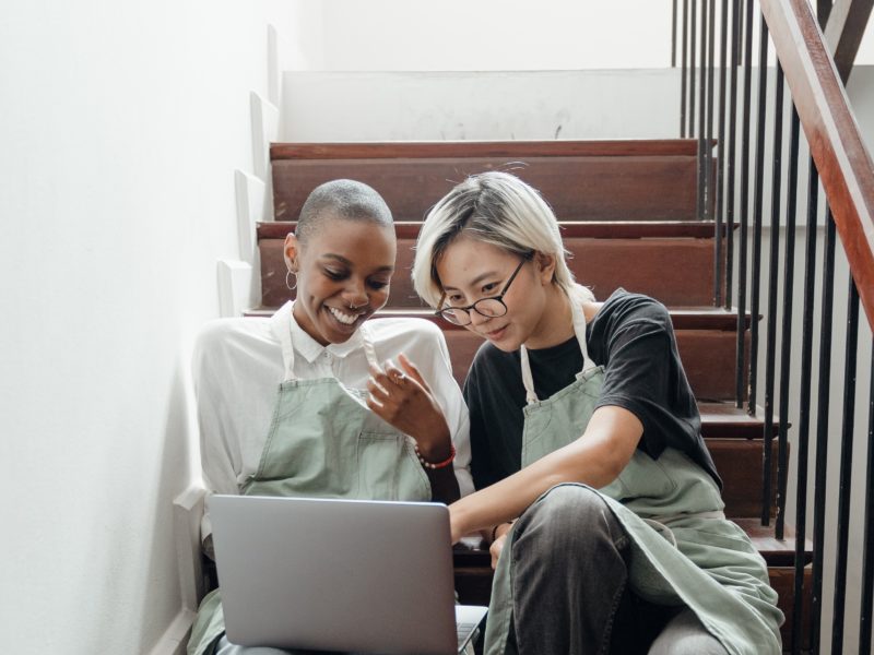 Young barristas watching a video sitting on the stairs