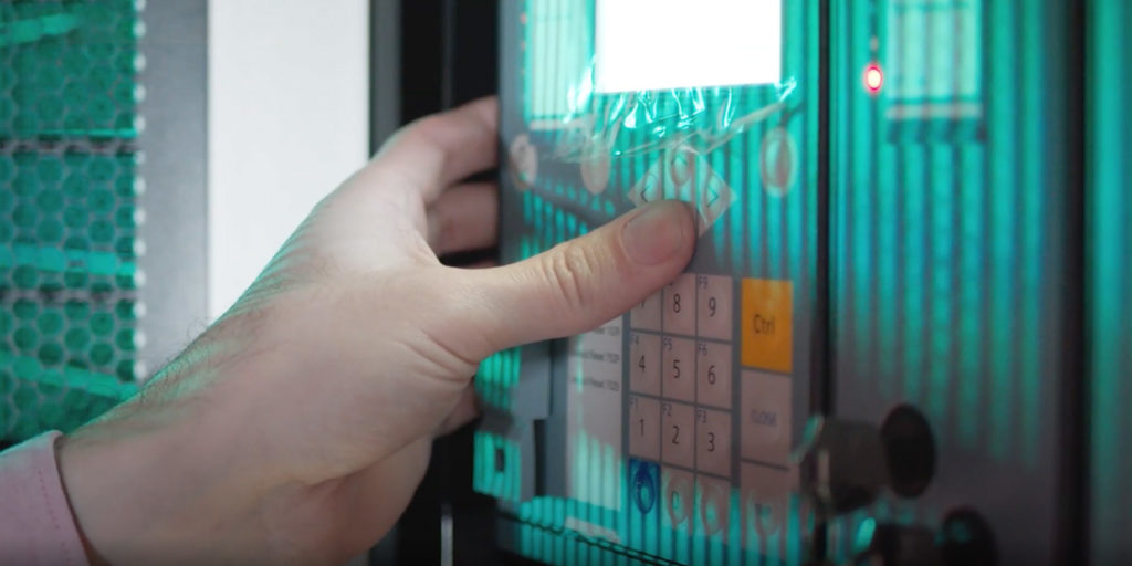 Hand pressing buttons on a security keypad.