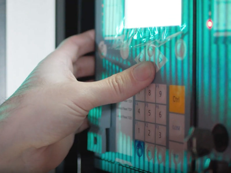 Hand pressing buttons on a security keypad.