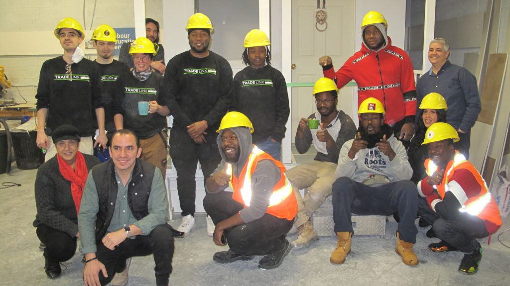Group photo of construction graduates wearing hard hats.