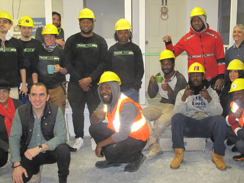 Group photo of construction graduates wearing hard hats.