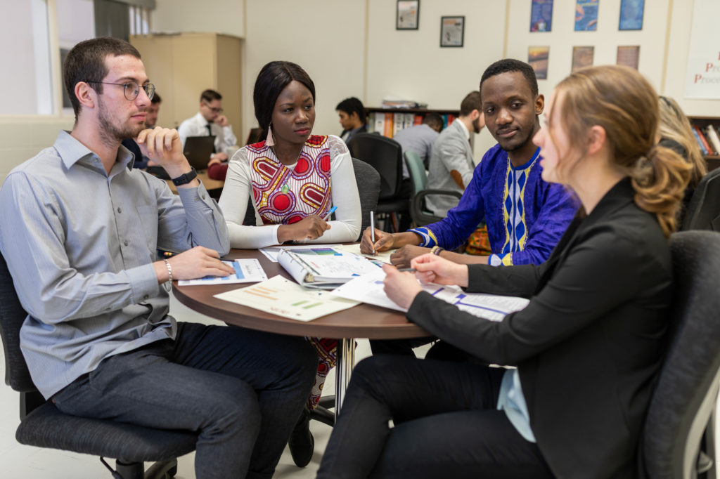 Group of community college students sitting around a table discussing.