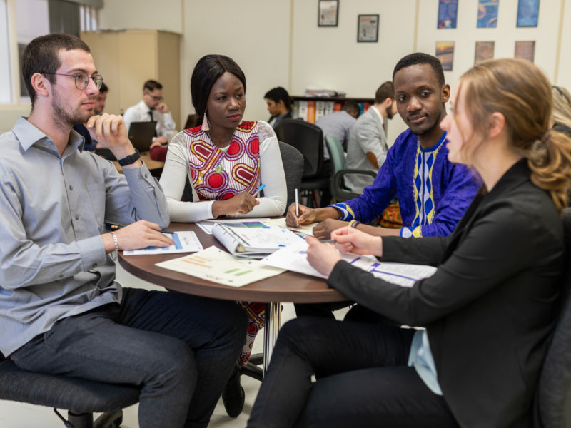 Group of community college students sitting around a table discussing.