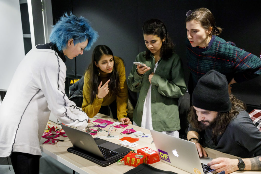 Group of textile students looking over samples of fabric.