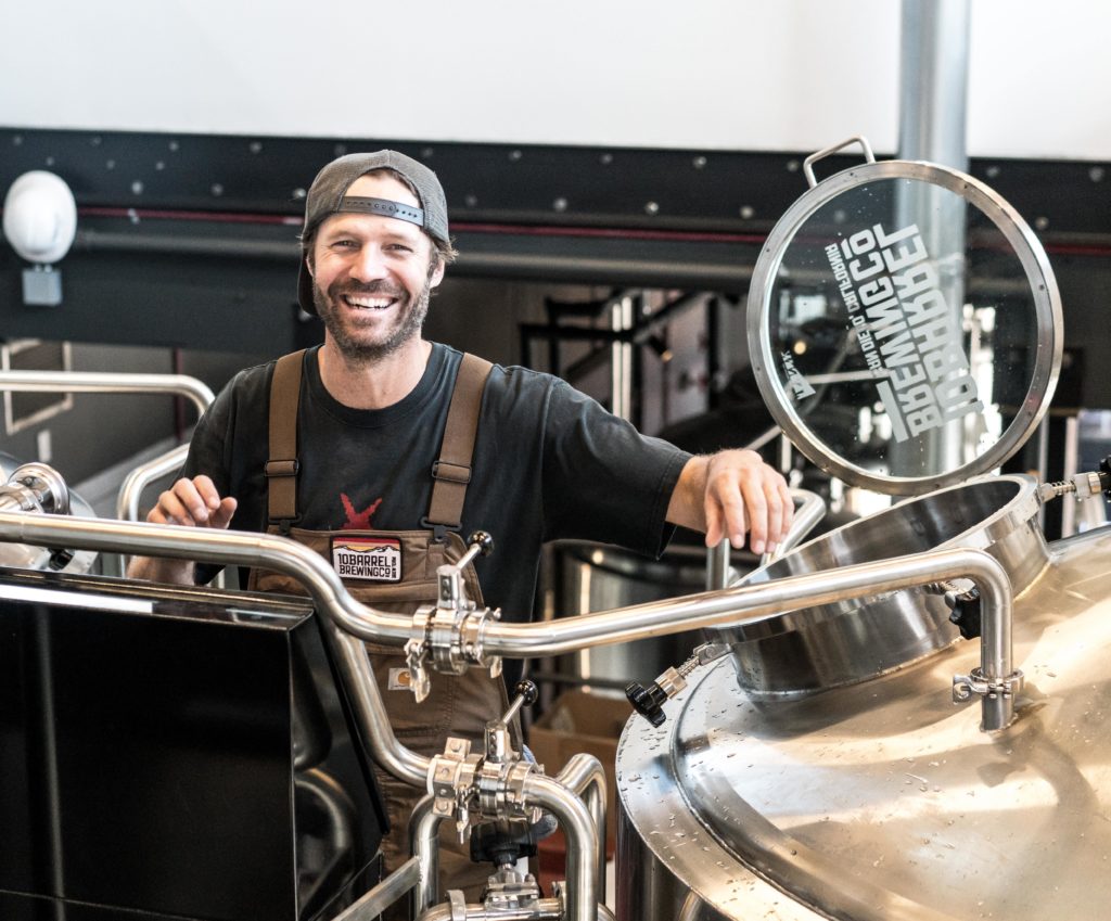 Man smiling while working in a beer brewing factory.