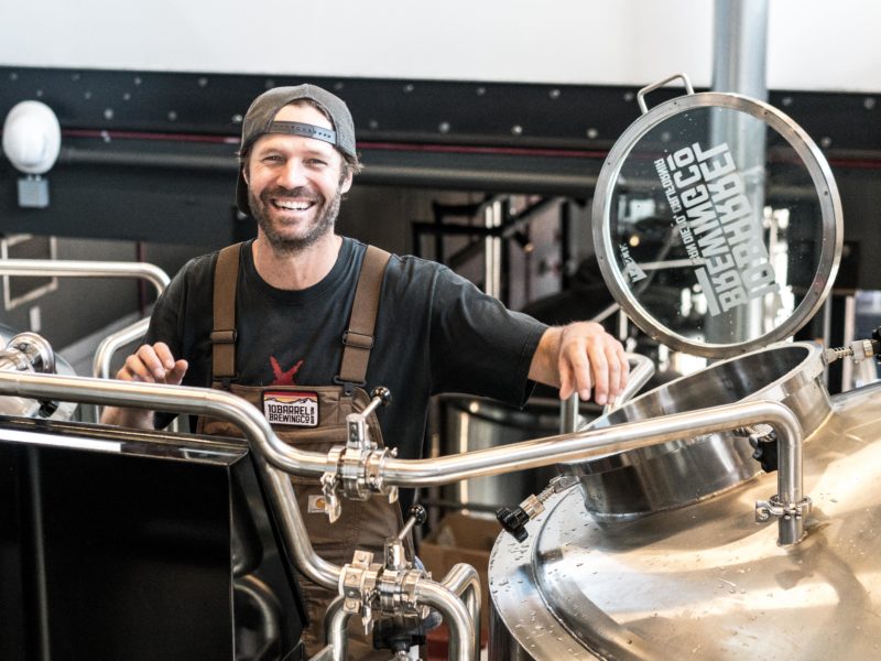 Man smiling while working in a beer brewing factory.