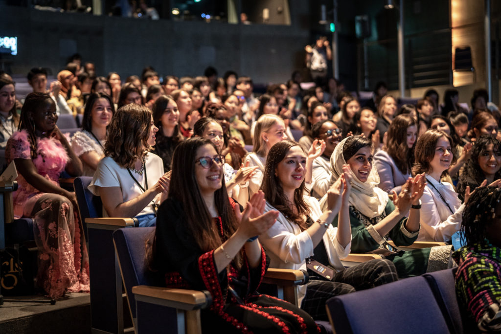 Group of young woman clapping during an event.