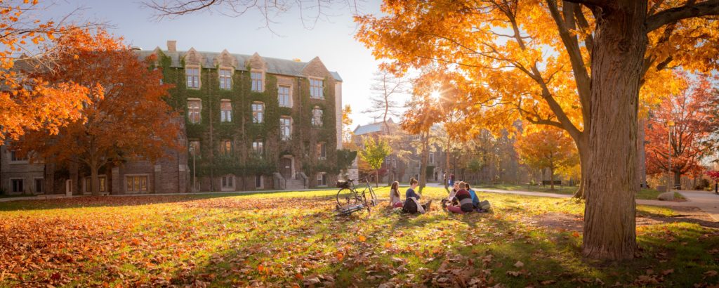 A group of students sitting outside on university campus.