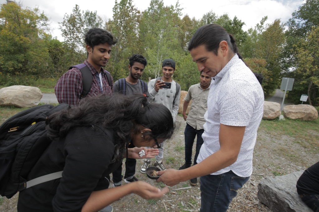 Students on a field trip peering in a bowl