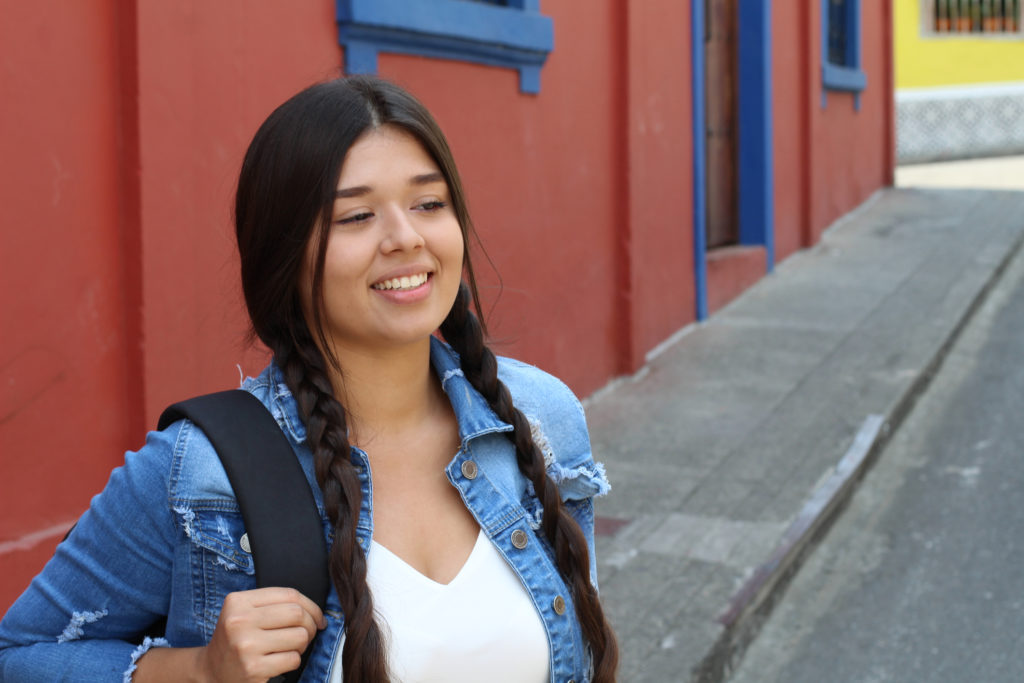 Young student wearing a backpack smiling.