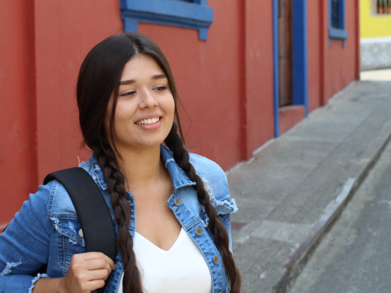 Young student wearing a backpack smiling.