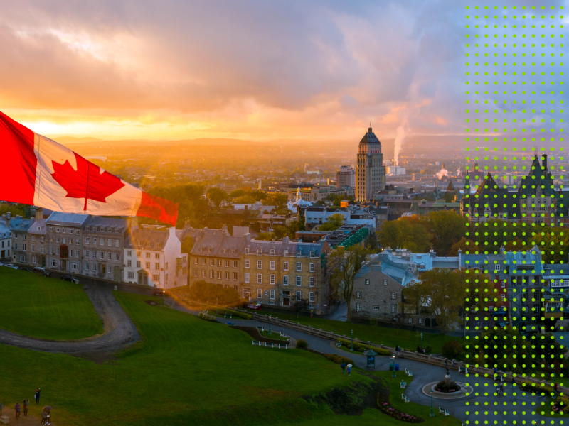 Aerial panorama view of Old Quebec City with the Canadian flag in front of a sunset