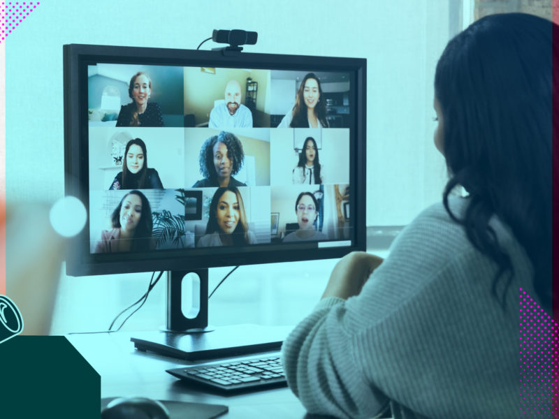 Person sitting at a table with computer screen showing video conference call