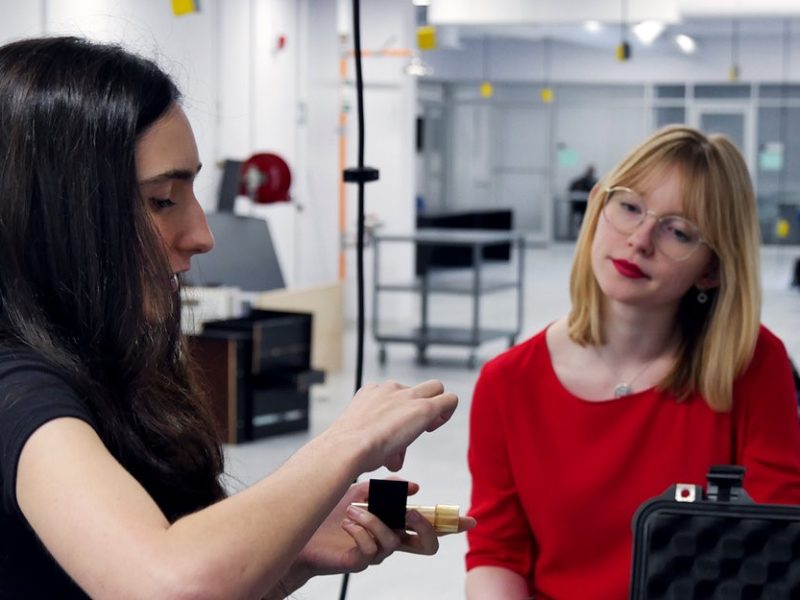 Two people sitting in a technology lab.