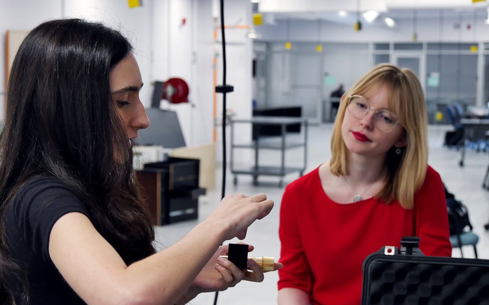 Two people sitting in a technology lab.