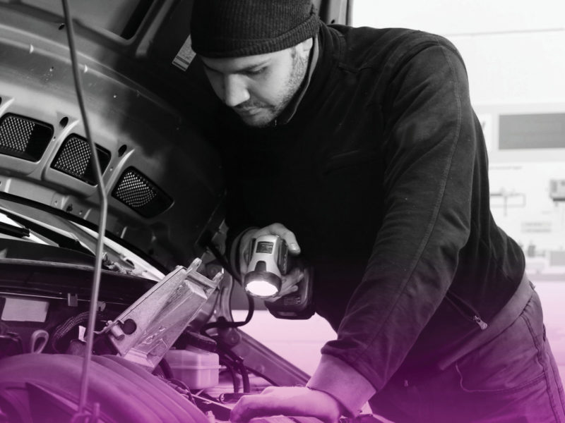 Person looking under the hood of a car