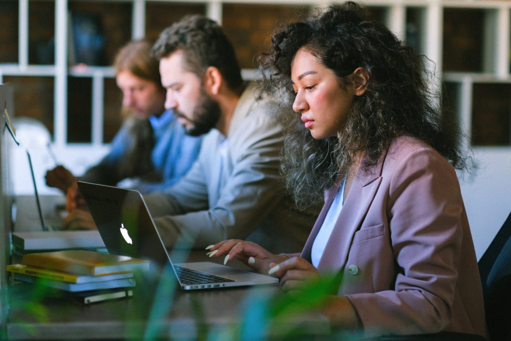 three people working at laptops