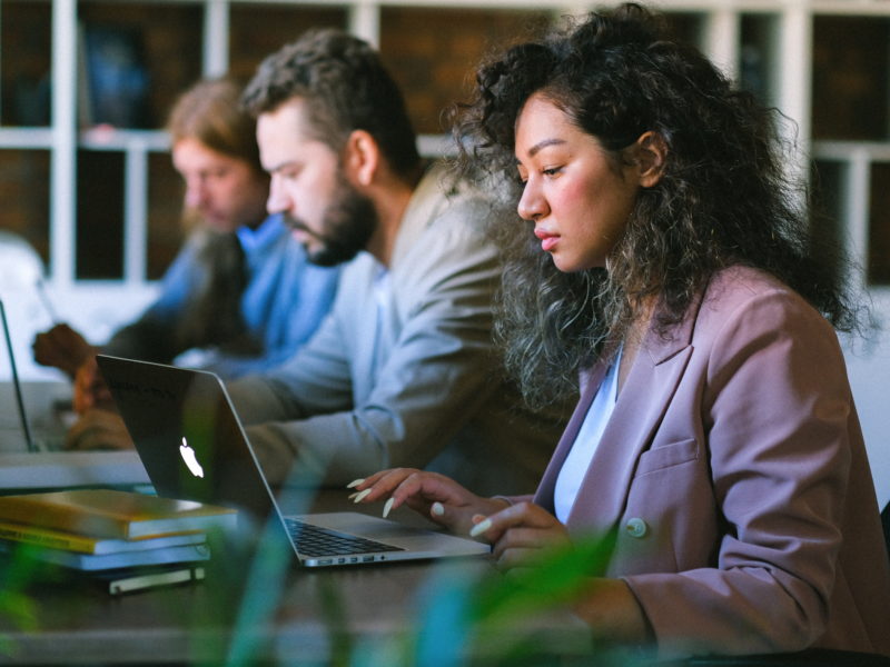 three people working at laptops