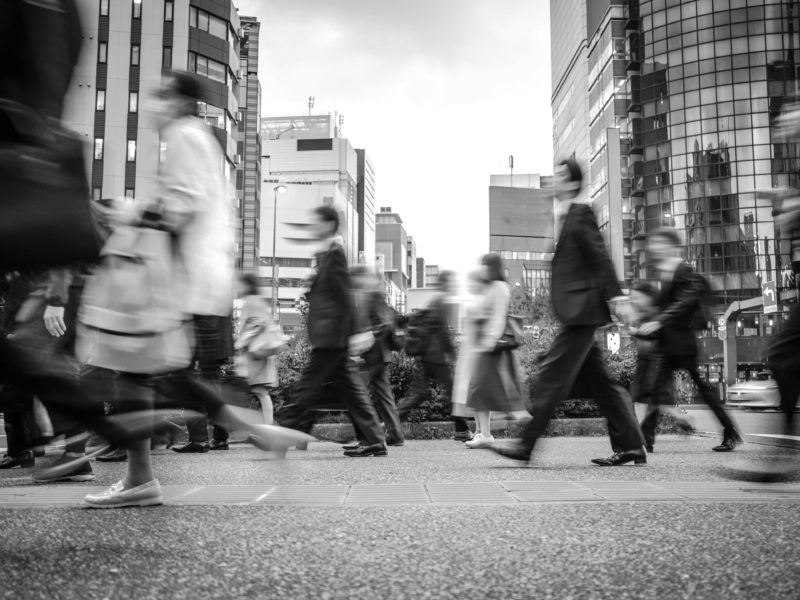 Street scene of groups of people crossing the street