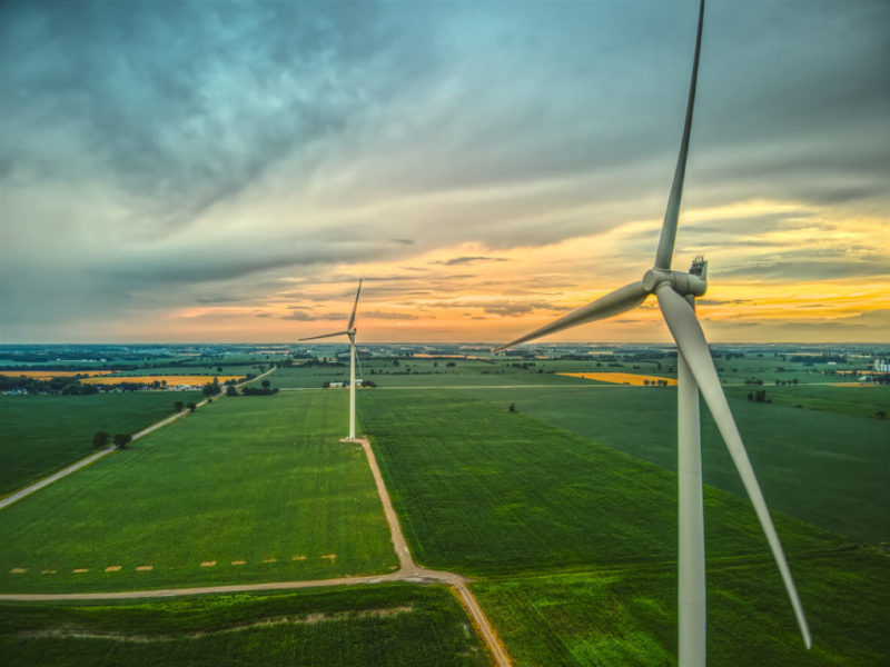 horizan of green land with windmill in the foreground