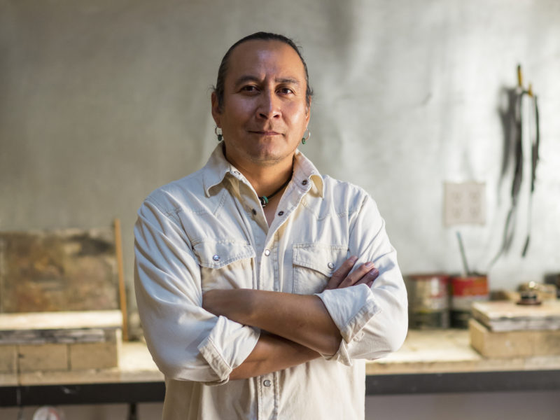 Native American jeweler standing in studio