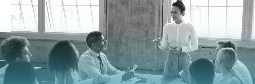 young person talking in front of a group in an office