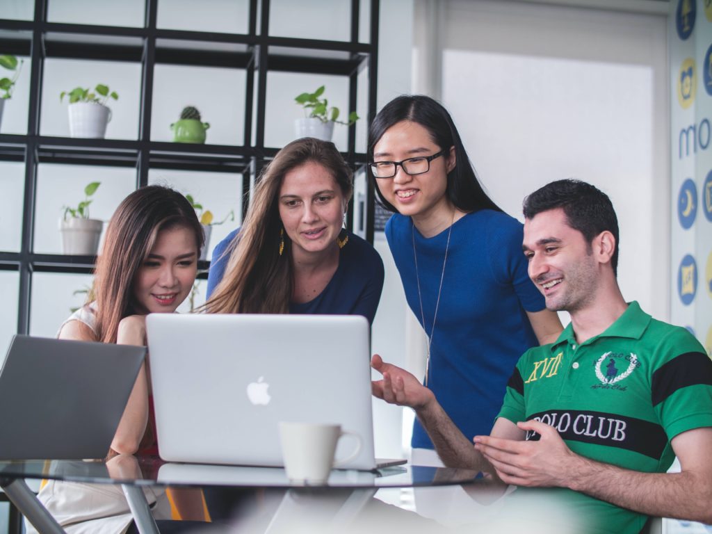 group of people working around a computer