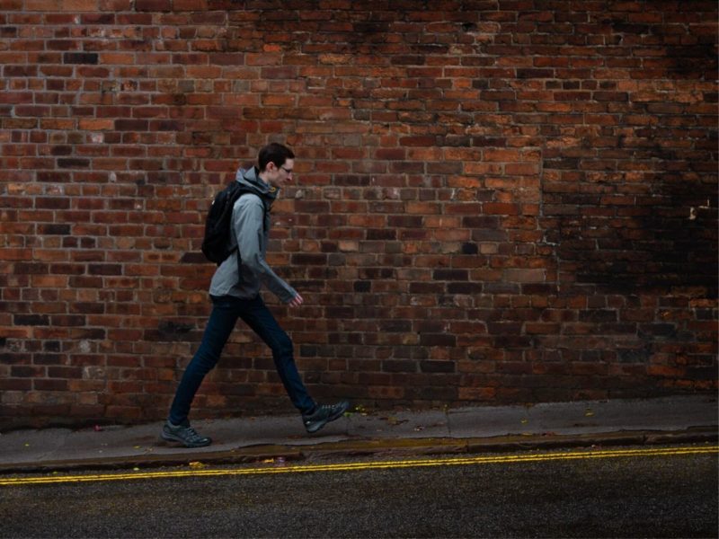 person with a backpack walking down a street