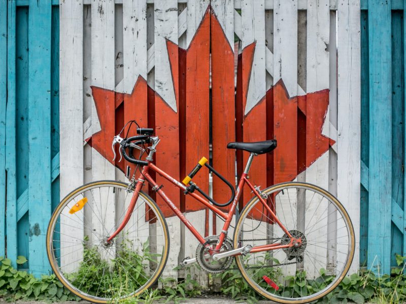 image of a maple leaf painted on a building and a bicycle in front
