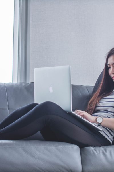 woman relaxes on couch with a laptop