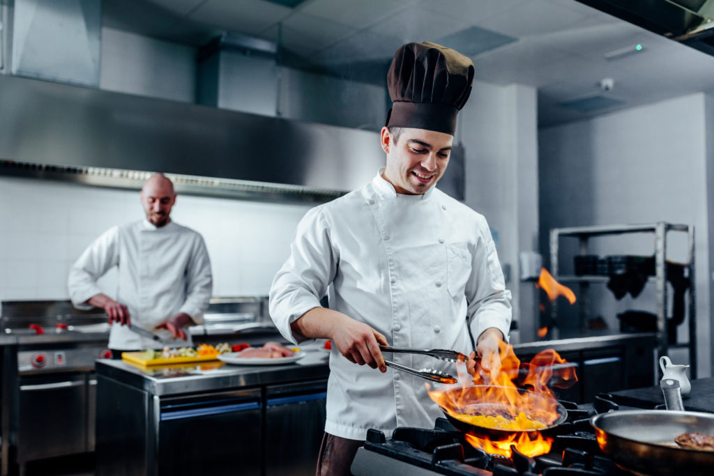 Shot of two young cooks preparing food in the kitchen