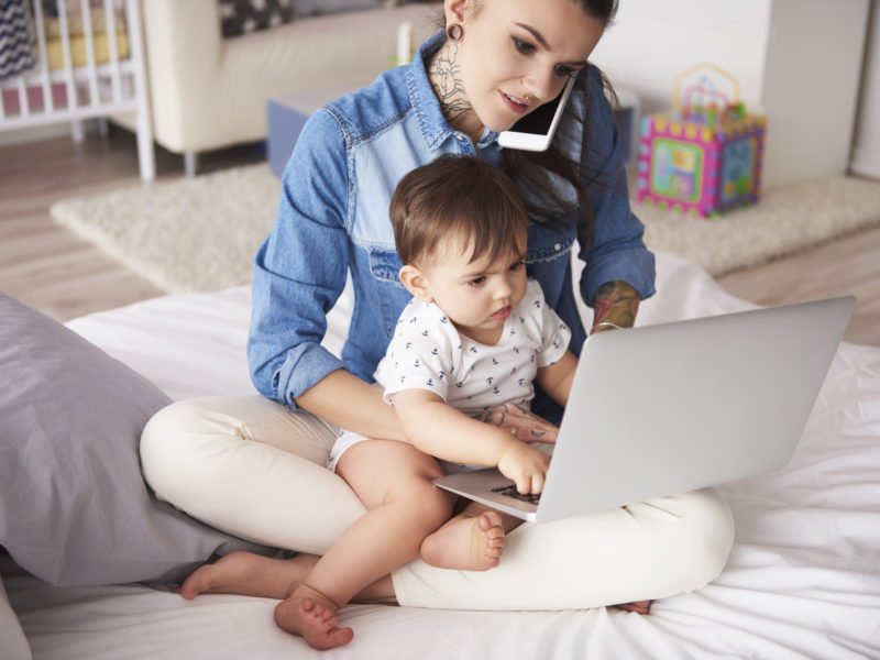 Young mother working from home with son